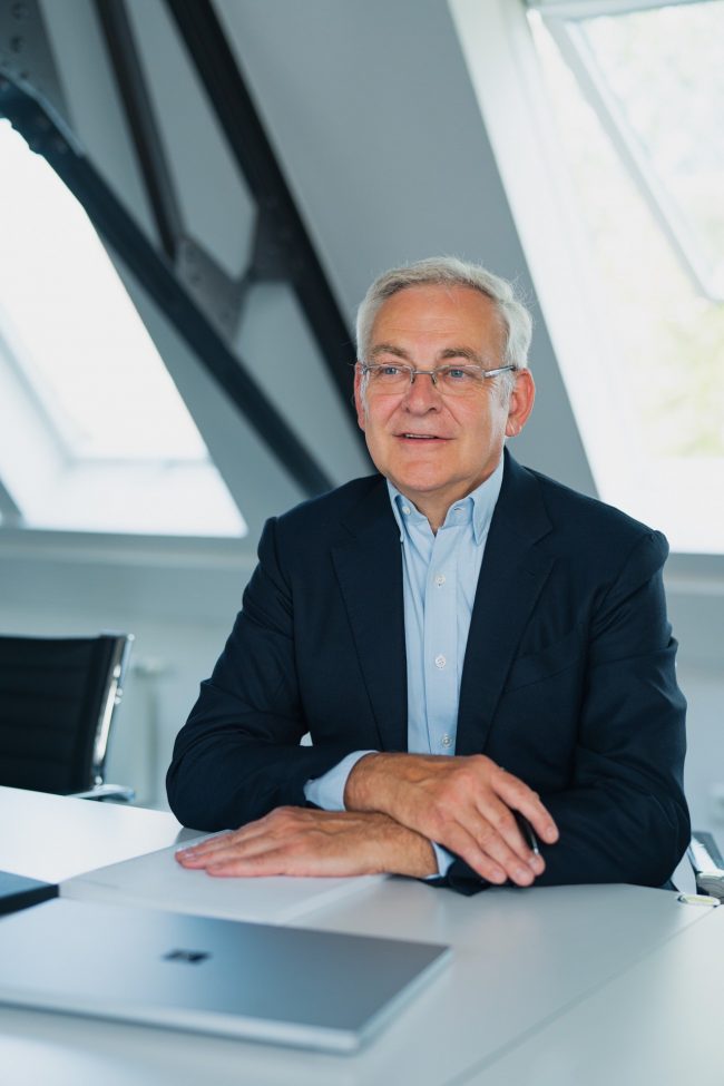 Heribert Vosdellen sitzt im Büro von Virnich Partners Kreditversicherungsmakler in Mönchengladbach am Schreibtisch